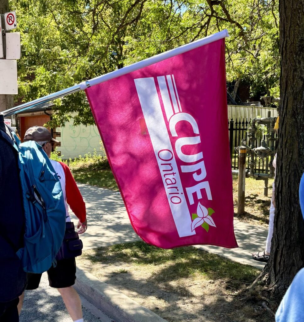 A sun-dappled CUPE Ontario flag, held by a CUPE 3903 member.